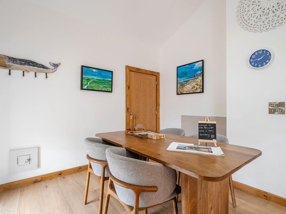 A dining room with a table and chairs at Hen Penmynydd in Llanfwrog near Llanfachraeth