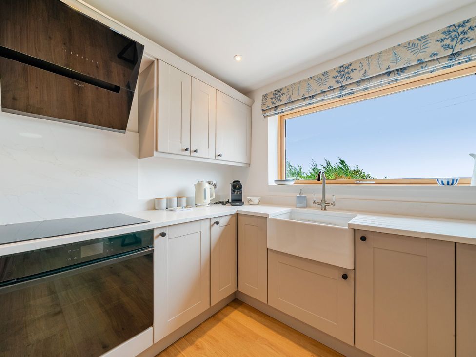A kitchen with cabinetry and appliances at Hen Penmynydd in Llanfwrog near Llanfachraeth