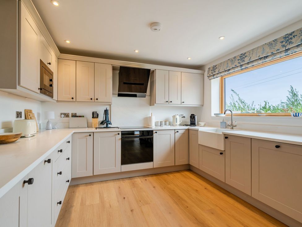 A kitchen with cabinets, sink, and appliances at Hen Penmynydd Llanfwrog near Llanfachraeth
