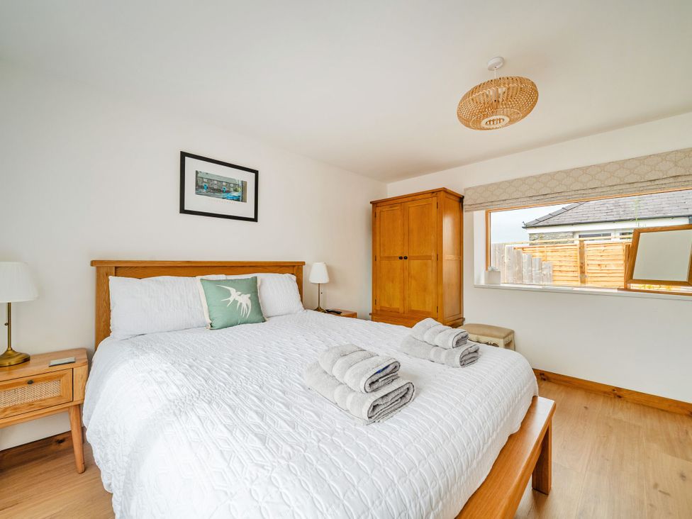 A bedroom with a large bed and wardrobe at Hen Penmynydd in Llanfwrog near Llanfachraeth