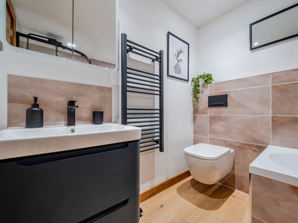 A bathroom with sink and wall-mounted toilet at Hen Penmynydd in Llanfwrog near Llanfachraeth