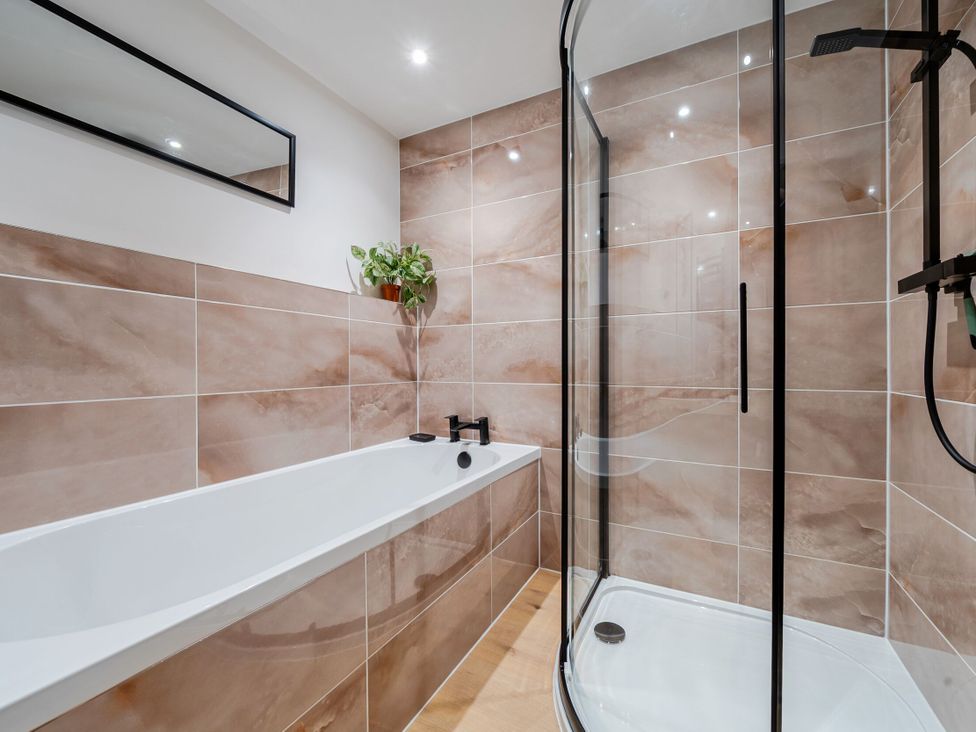 A bathroom with a bathtub and shower at Hen Penmynydd in Llanfwrog near Llanfachraeth