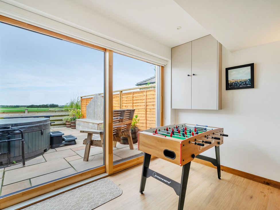 A game room with a foosball table and a hot tub at Hen Penmynydd in Llanfwrog near Llanfachraeth