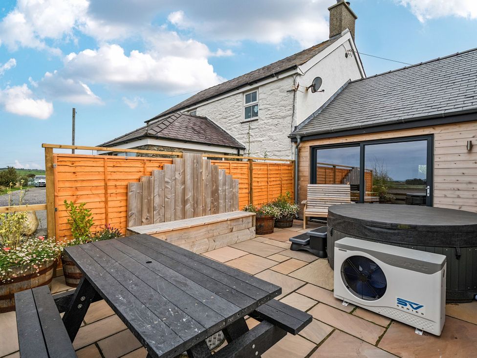 An outdoor space with a table and benches at Hen Penmynydd Llanfwrog near Llanfachraeth