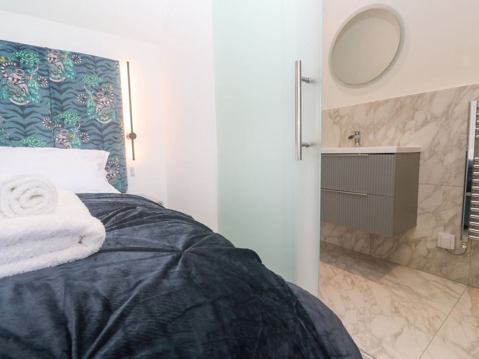 A bedroom with a bed and bathroom area at Shearwater in Praa Sands