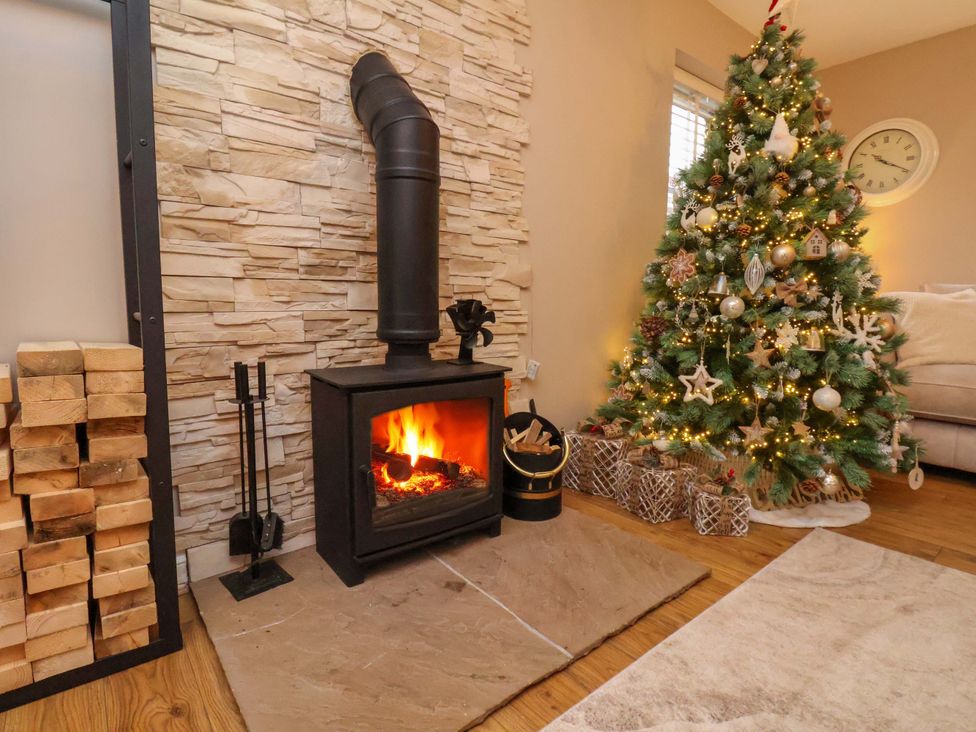 A living room with a fireplace and a decorative Christmas tree at 23 Main Street