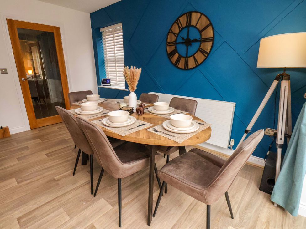A dining room with a round table and six chairs at 23 Main Street
