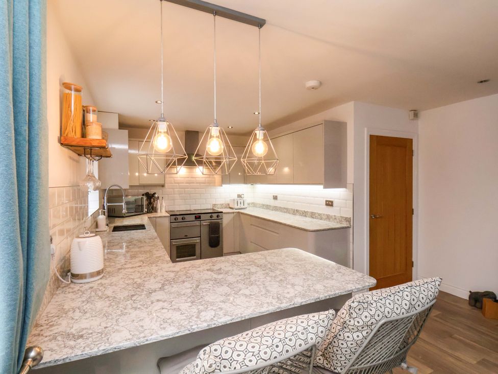 A kitchen with bar stools and cabinets at 23 Main Street 
