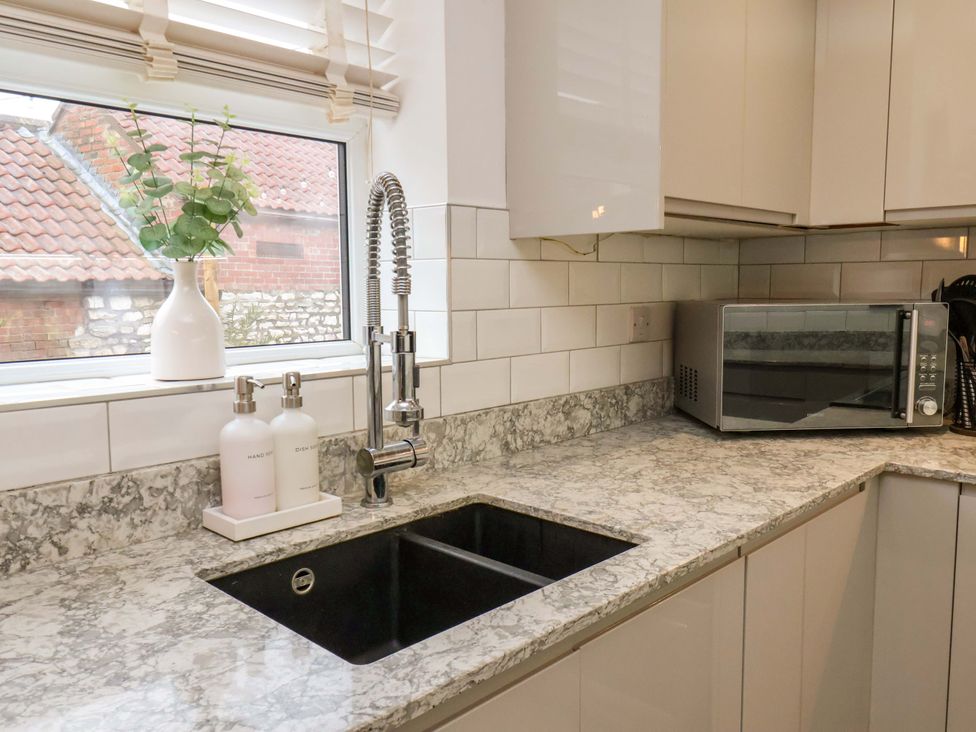 A kitchen with a sink and microwave at 23 Main Street