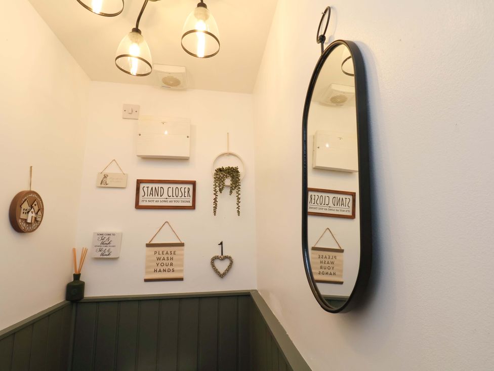 A bathroom with a mirror and decorative signs at 23 Main Street