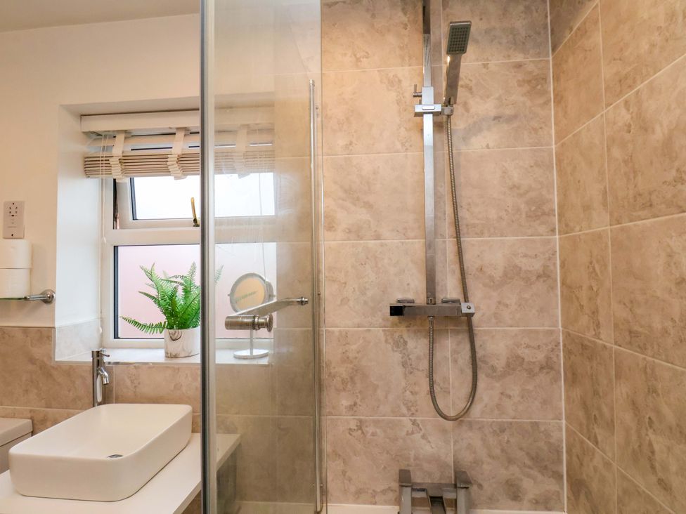 A bathroom with a shower and sink at 23 Main Street