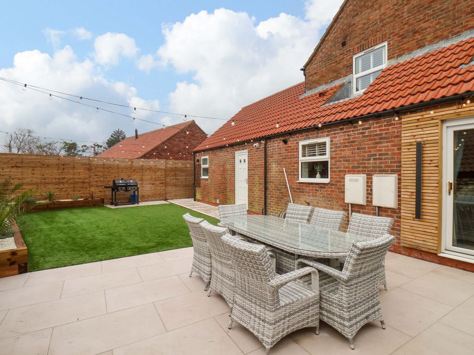 A garden with a glass table and chairs at 23 Main Street 