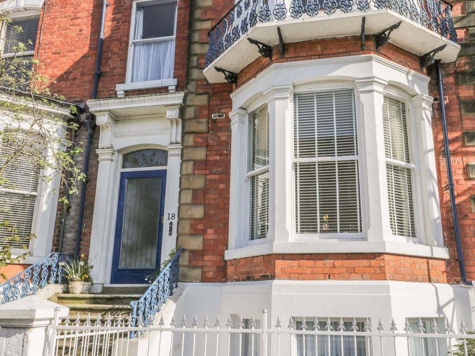 A building exterior with a blue door and railings at Esplanade Gardens, Apartment 1 in Scarborough