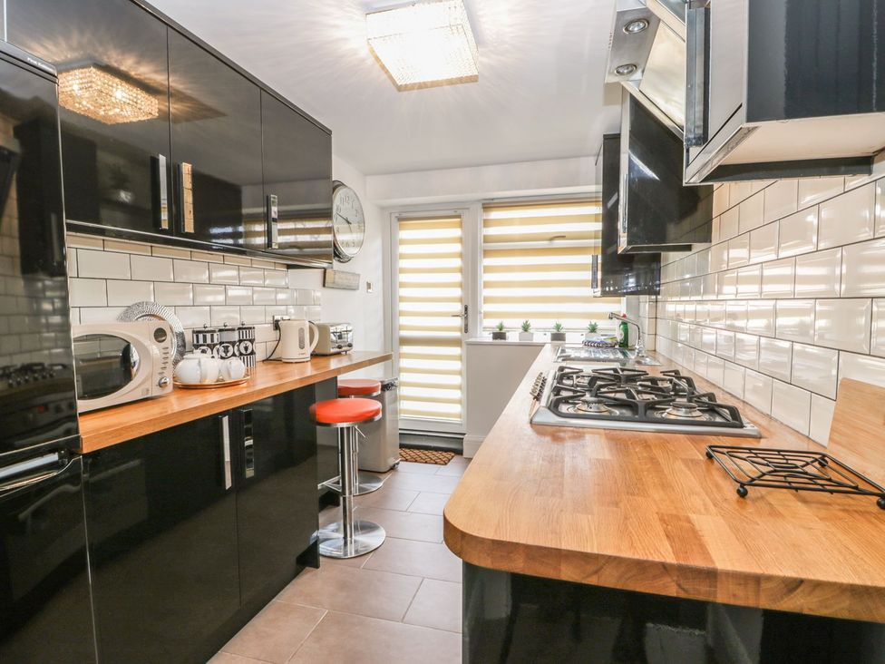 A kitchen with a stove and microwave at Esplanade Gardens, Apartment 1 in Scarborough