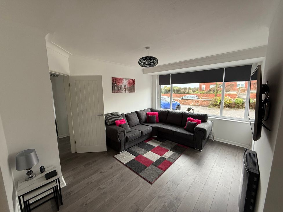 A living room with a sofa and television at Beach Side Bungalow