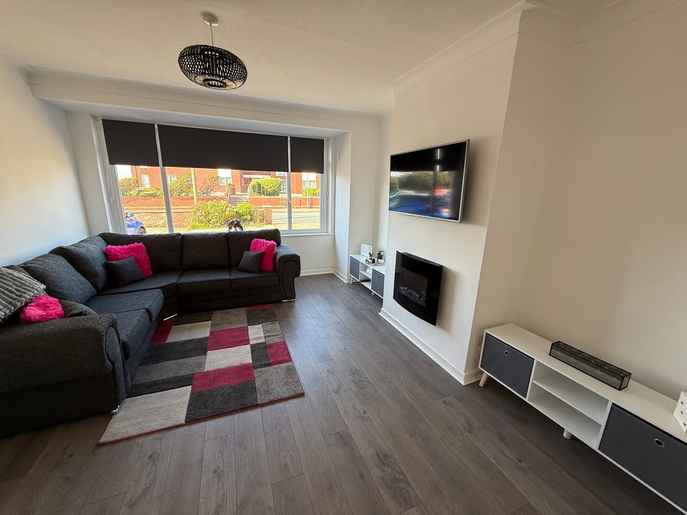 A living room with a sofa and television at Beach Side Bungalow