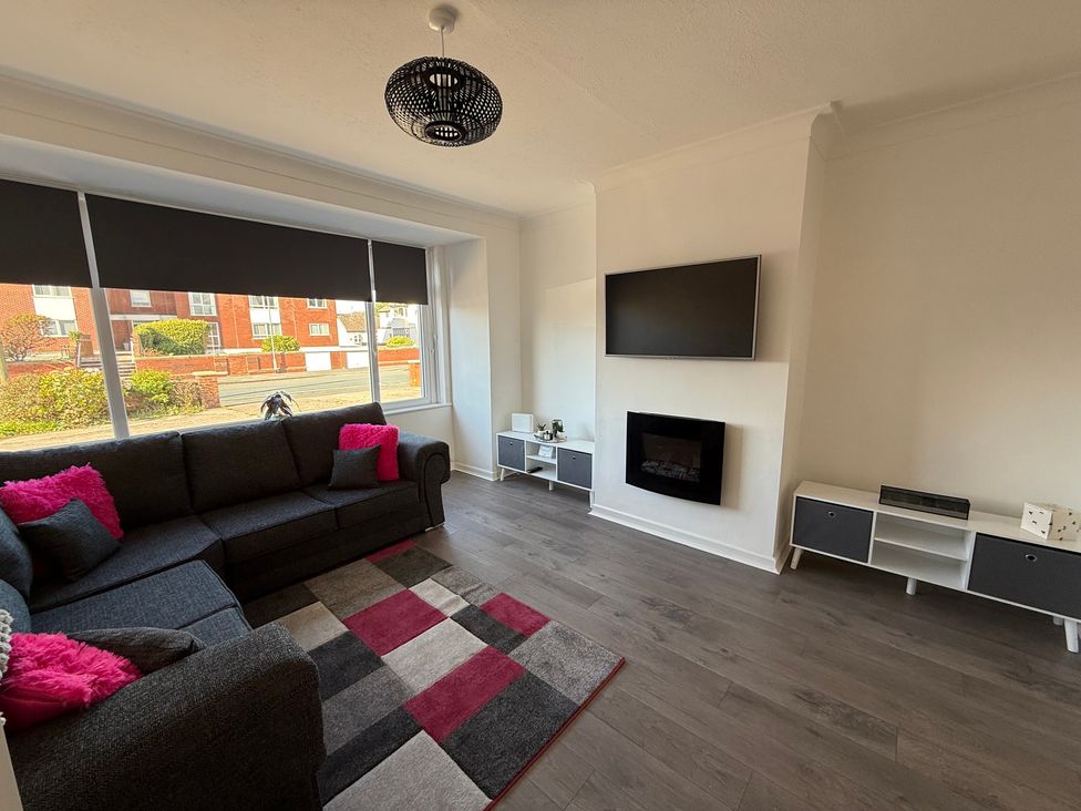 A living room with a sofa and television at Beach Side Bungalow
