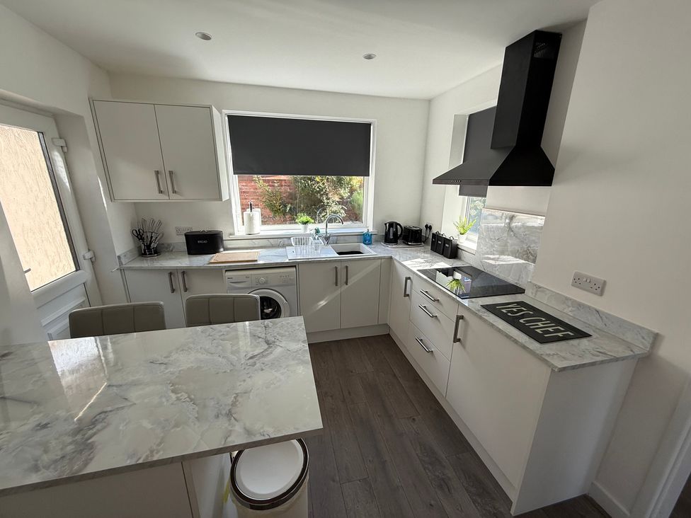 A kitchen with cabinets, stove, sink, and kitchen island at Beach Side Bungalow