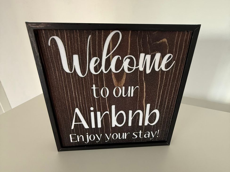 A welcome sign for Airbnb on a wooden texture at Beach Side Bungalow