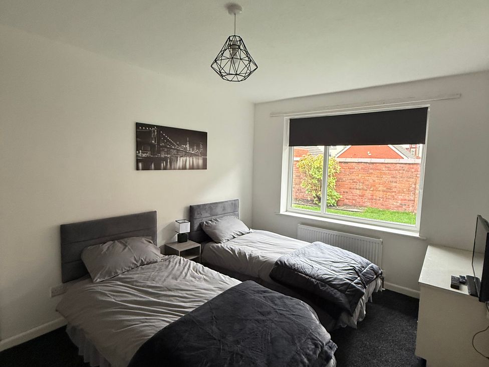 A bedroom with two beds and a window at Beach Side Bungalow