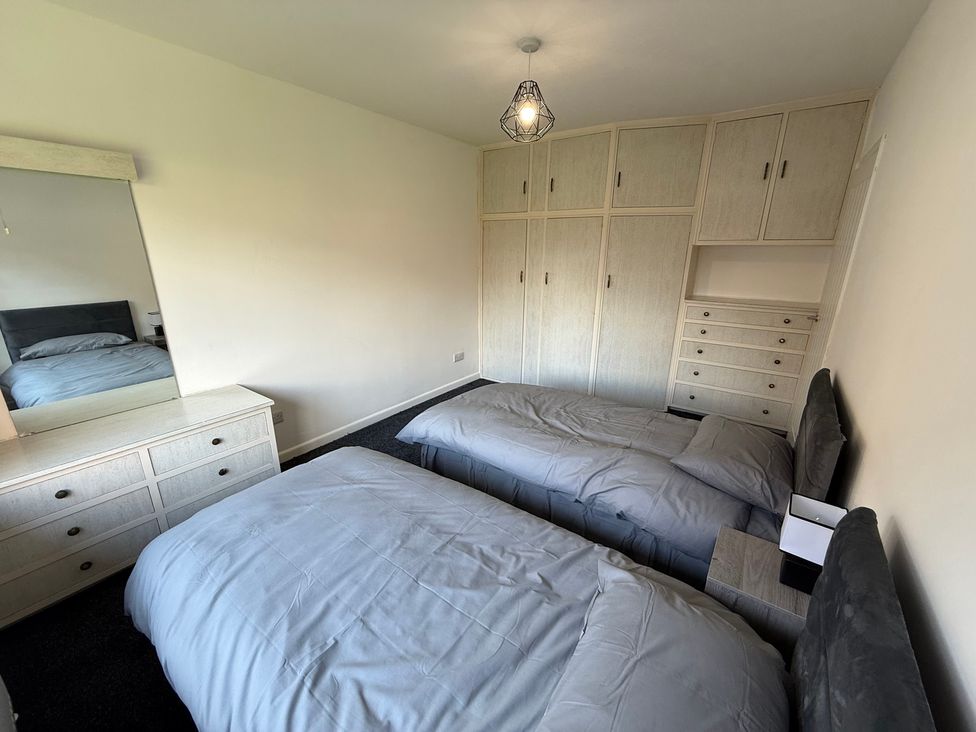 A bedroom with two beds and a dresser at Beach Side Bungalow
