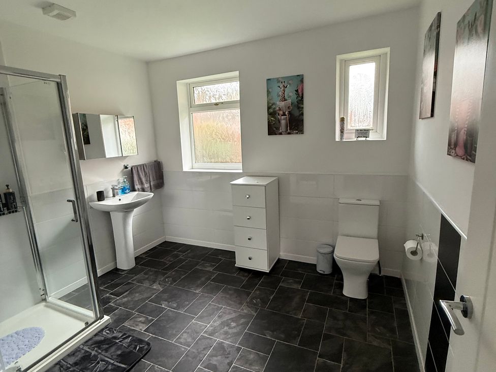 A bathroom with shower, sink, and toilet at Beach Side Bungalow
