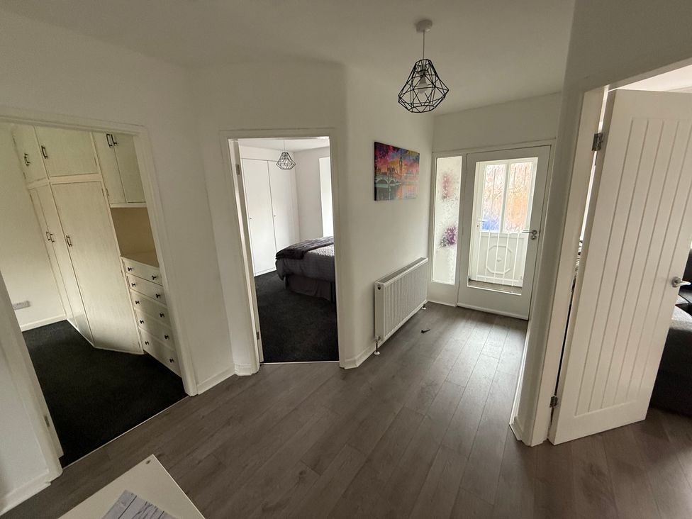 A hallway with doors leading to rooms and a window at Beach Side Bungalow