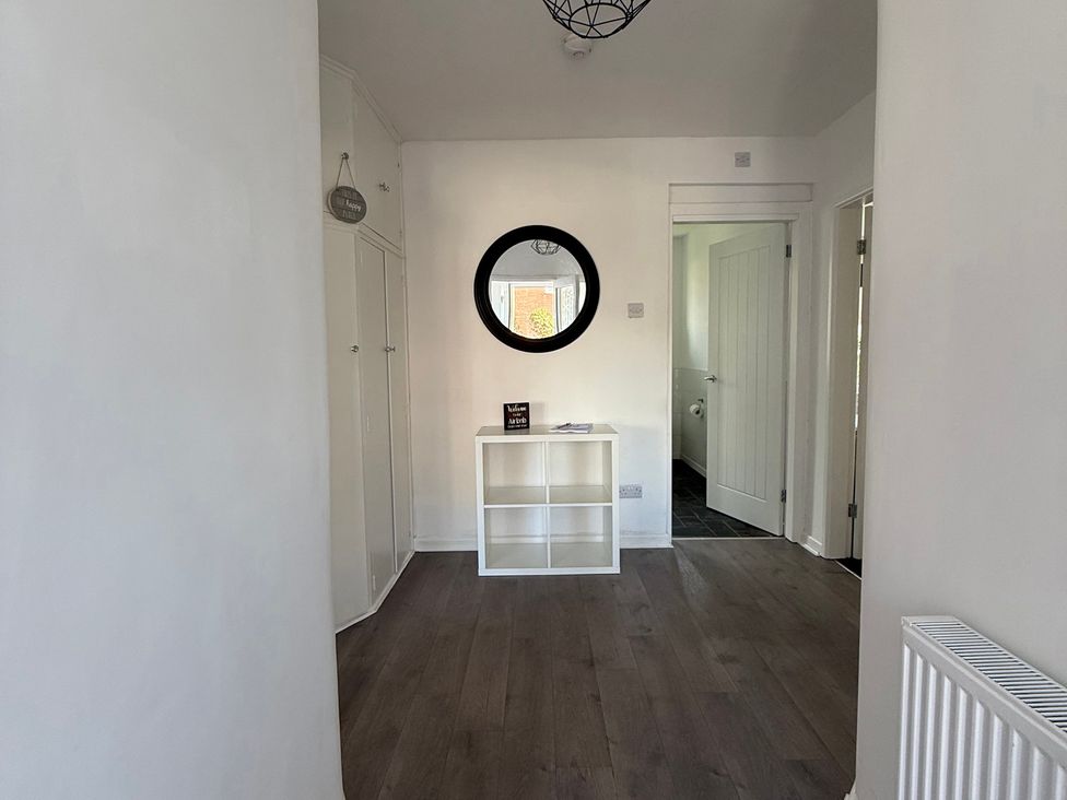 A hallway with a mirror and shelf at Beach Side Bungalow
