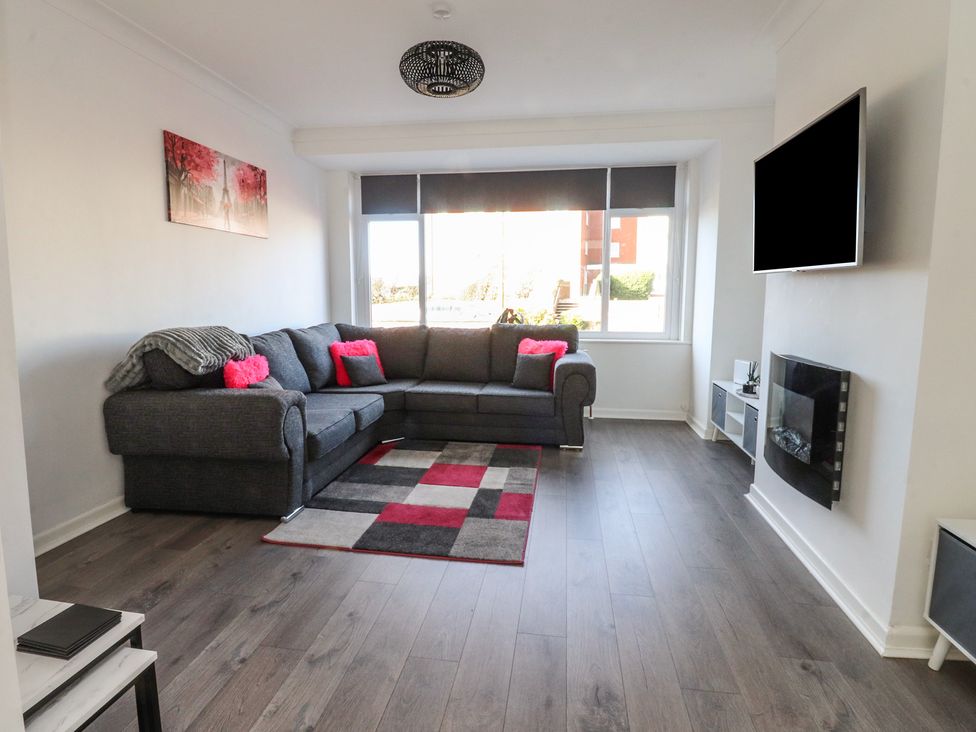A living room with a sofa and television at Beach Side Bungalow in Lytham St. Annes