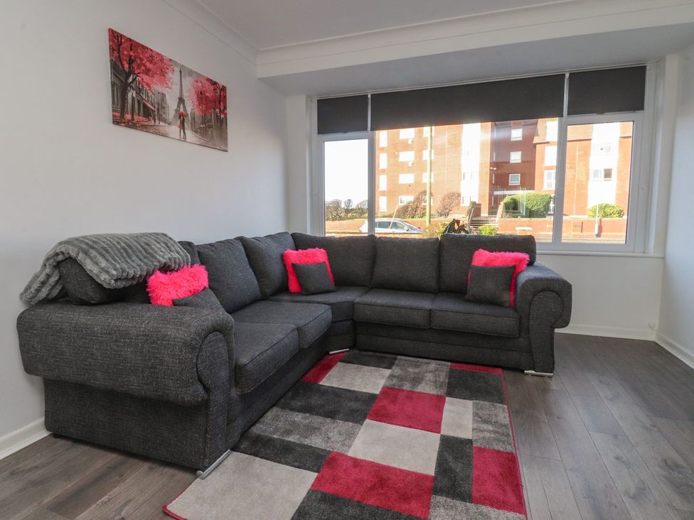A living room with a sofa and wall art at Beach Side Bungalow in Lytham St. Annes