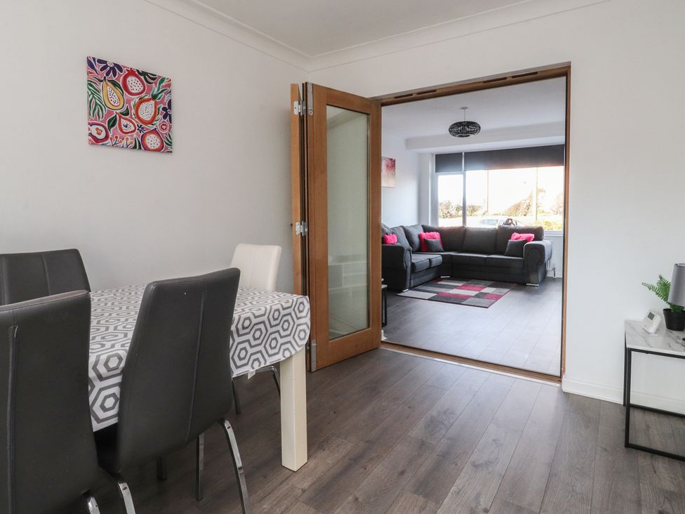 A dining room with a table and chairs and a view to a living area at Beach Side Bungalow in Lytham St. Annes