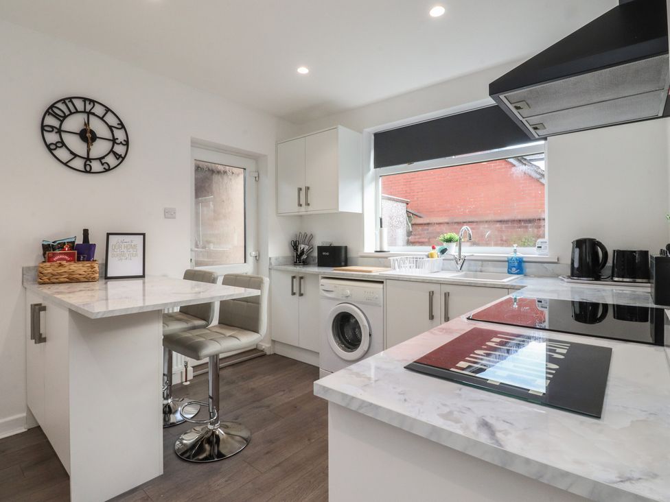 A kitchen with cabinets and an island at Beach Side Bungalow in Lytham St. Annes