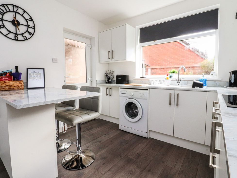 A kitchen with a washing machine and counter at Beach Side Bungalow in Lytham St. Annes