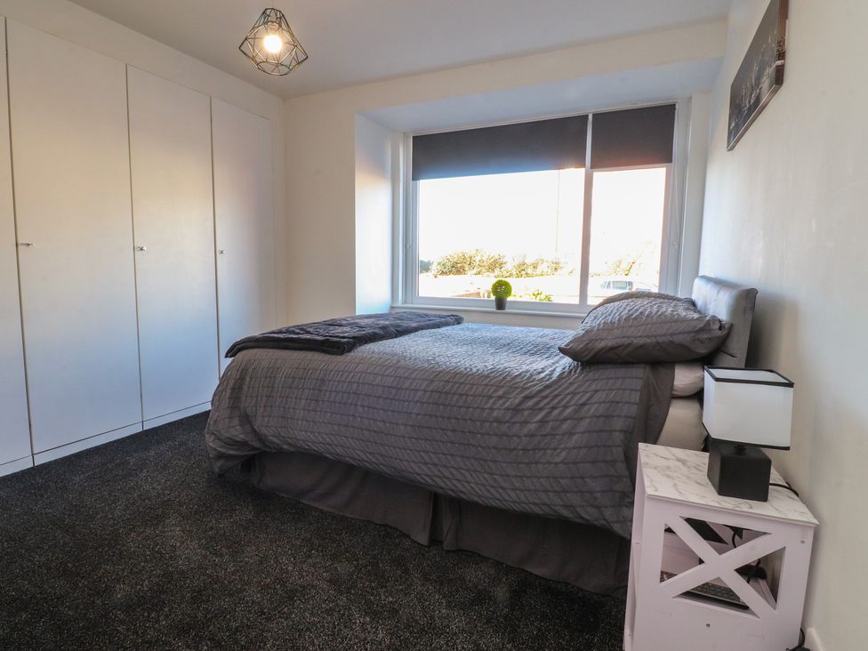 A bedroom with a bed and wardrobe at Beach Side Bungalow in Lytham St. Annes