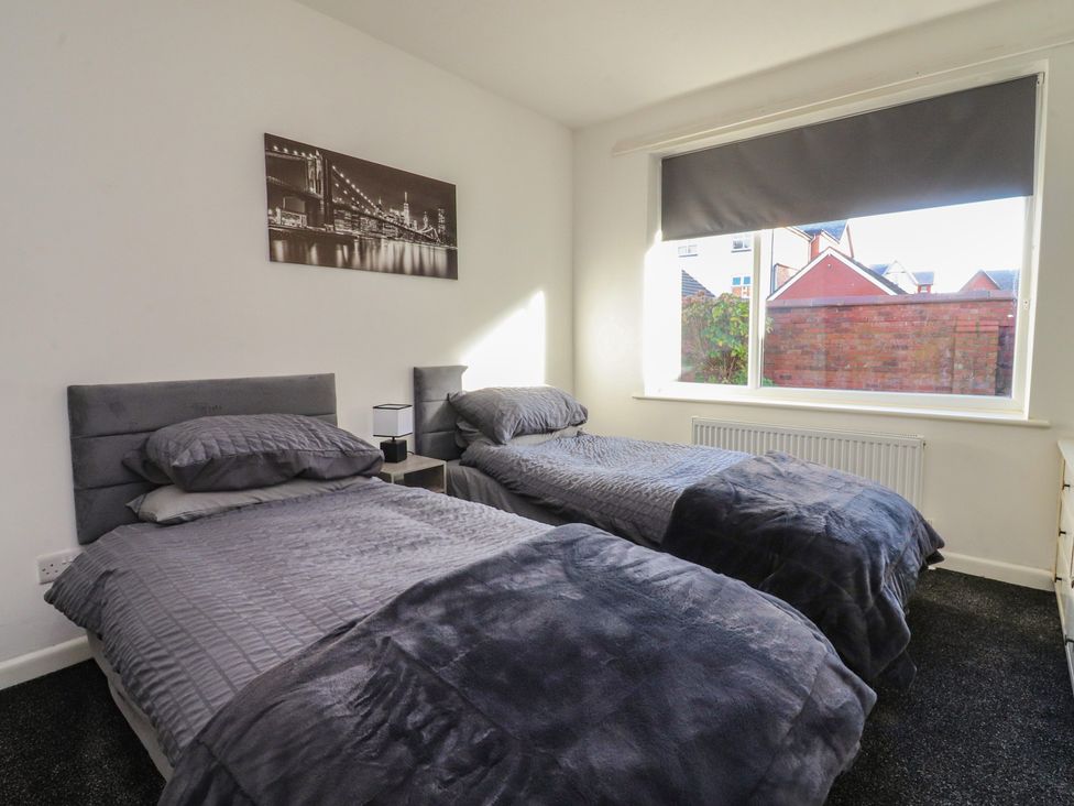A bedroom with two beds and a window at Beach Side Bungalow Lytham St. Annes