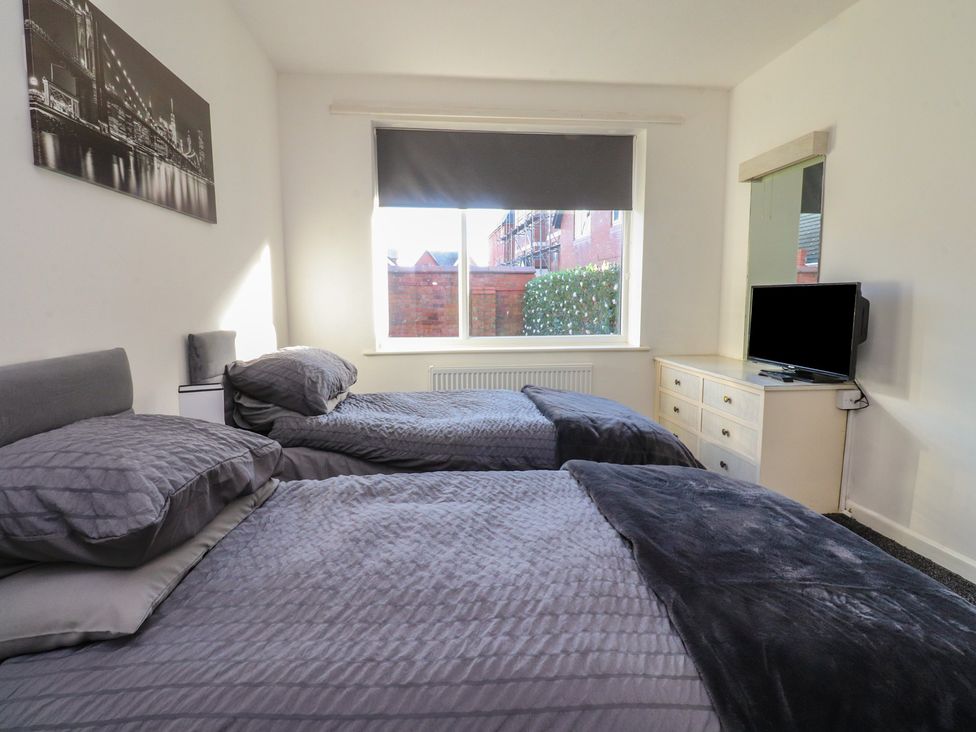 A bedroom with two beds and a television at Beach Side Bungalow in Lytham St. Annes