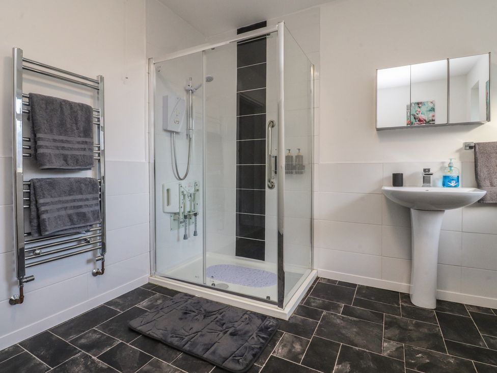 A bathroom with a shower and sink at Beach Side Bungalow in Lytham St. Annes
