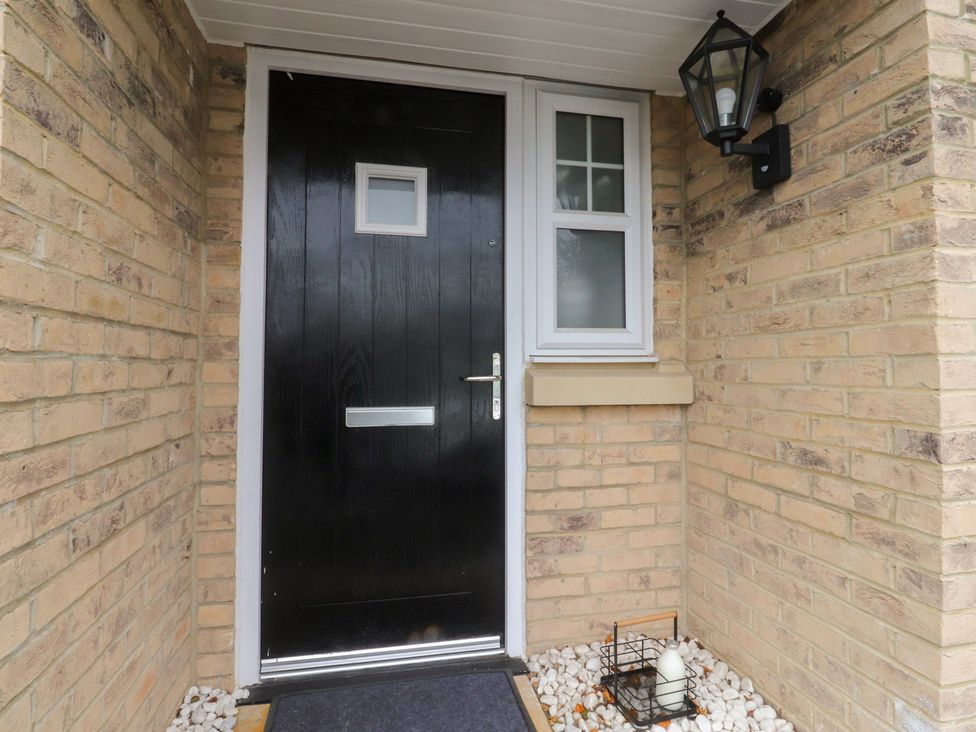 An entrance with a black front door and light fixture at 49 Mellings Place 