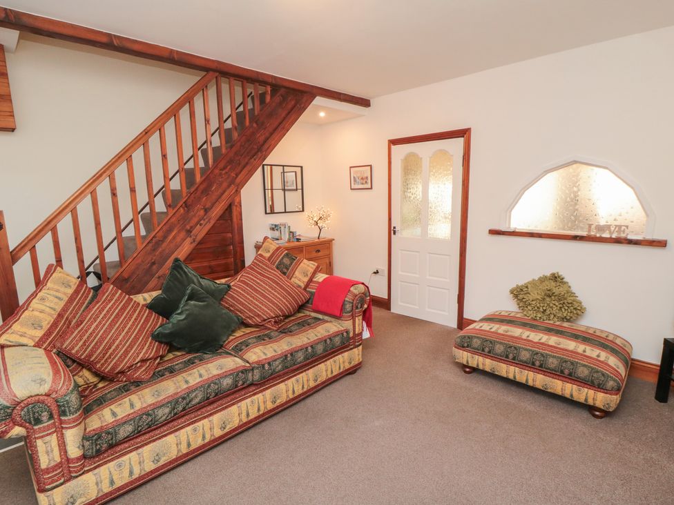 A living room with a sofa and footstool at Cliffe Cottage in Brotton, North Yorkshire
