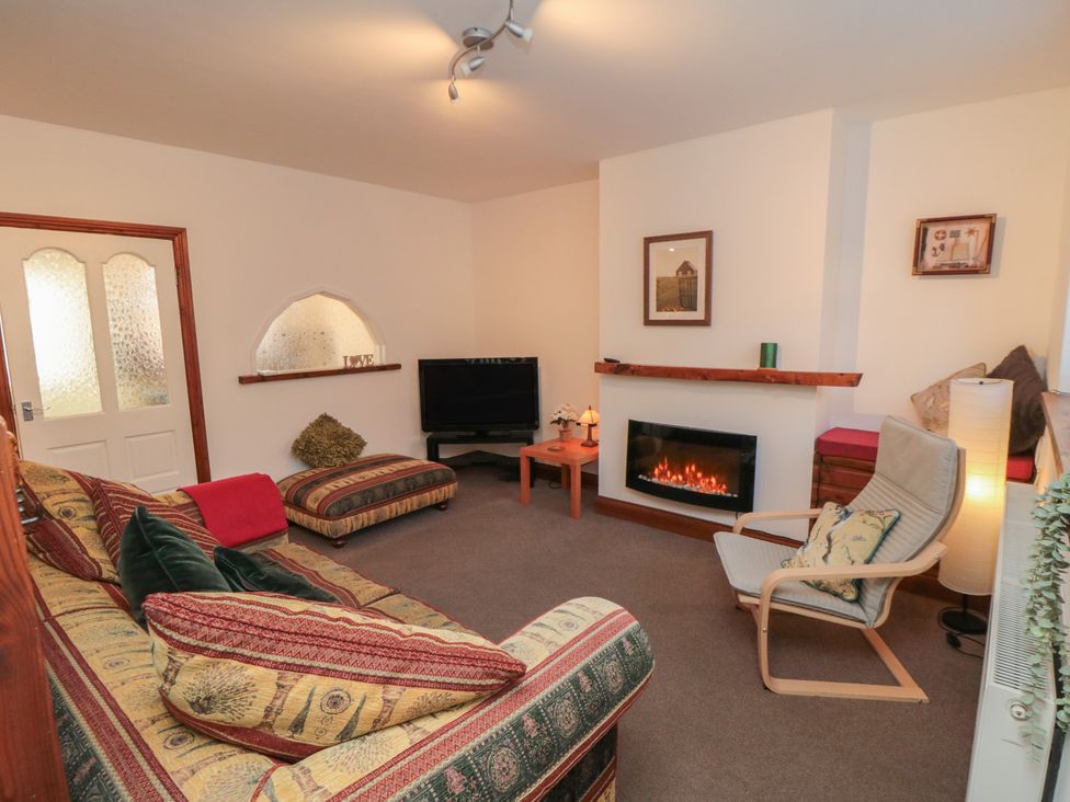 A living room with a television and an armchair at Cliffe Cottage in Brotton, North Yorkshire