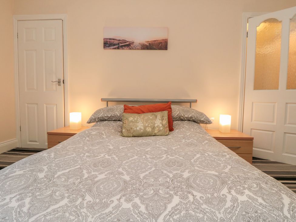 A bedroom with a bed and lamps at Cliffe Cottage in Brotton, North Yorkshire