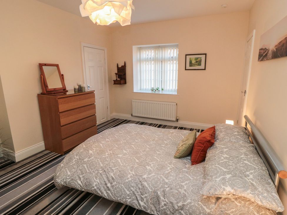 A bedroom with a bed and dresser at Cliffe Cottage in Brotton, North Yorkshire