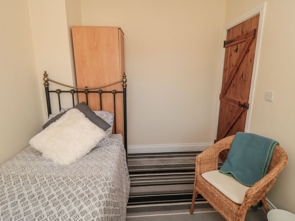 A bedroom with a bed and wardrobe at Cliffe Cottage in Brotton, North Yorkshire