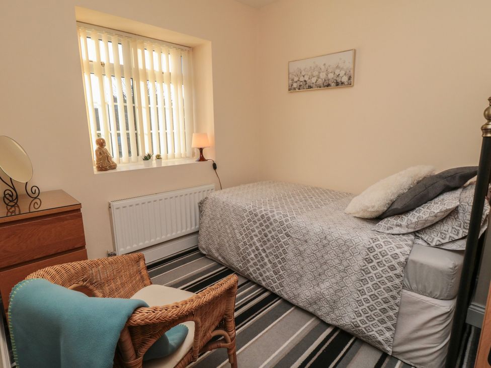 A bedroom with a single bed and a mirror at Cliffe Cottage in Brotton, North Yorkshire