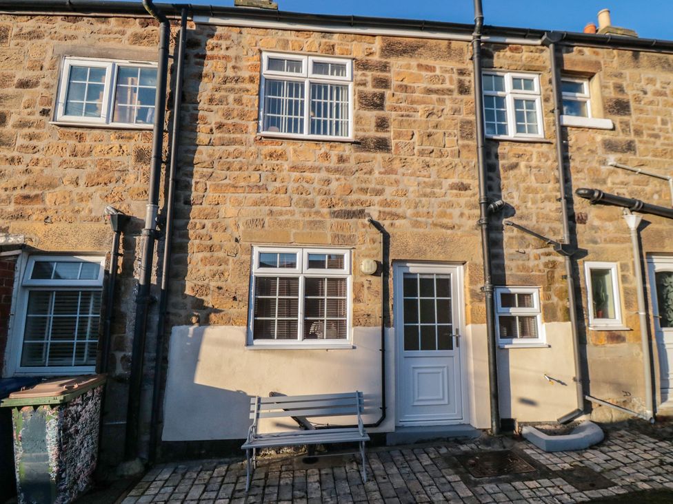 An exterior view of a stone cottage with windows and a door at Cliffe Cottage in Brotton, North Yorkshire