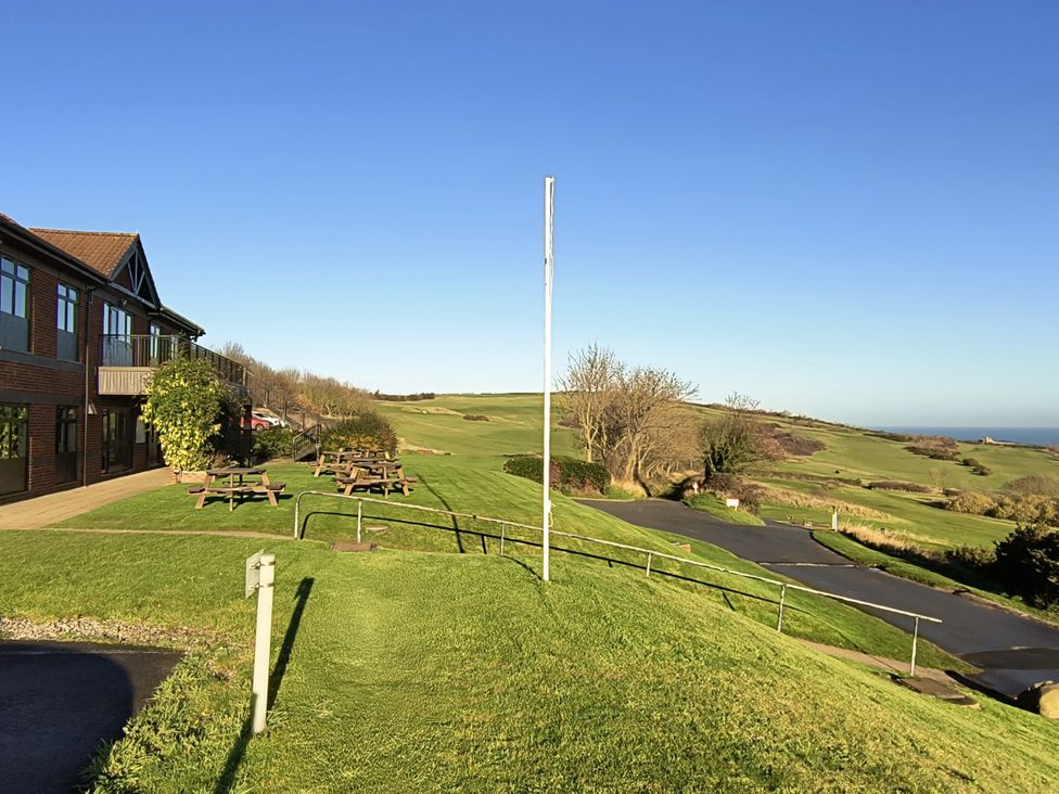 An outdoor area with benches and a building at Cliffe Cottage Brotton, North Yorkshire