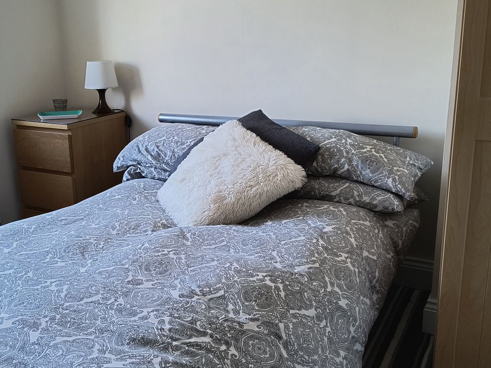 A bedroom with a bed and bedside table at Cliffe Cottage in Brotton, North Yorkshire