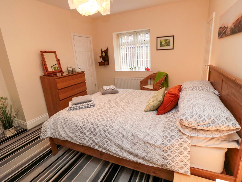 A bedroom with a bed and dresser at Cliffe Cottage in Brotton, North Yorkshire