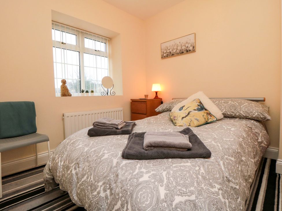 A bedroom with a bed and a chair at Cliffe Cottage in Brotton, North Yorkshire