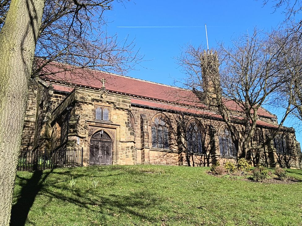A church building with stone walls and a tower at Cliffe Cottage in Brotton, North Yorkshire